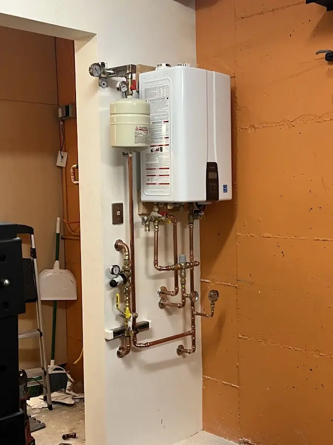 Plumbing technician inspecting water heater connections in Libertyville